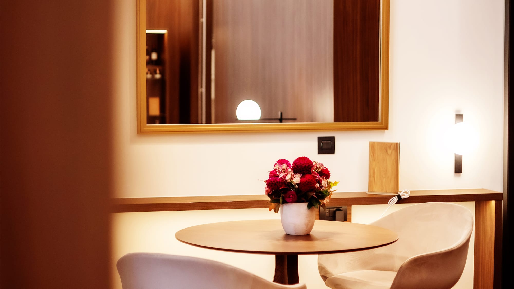 a table with chairs and a vase of flowers