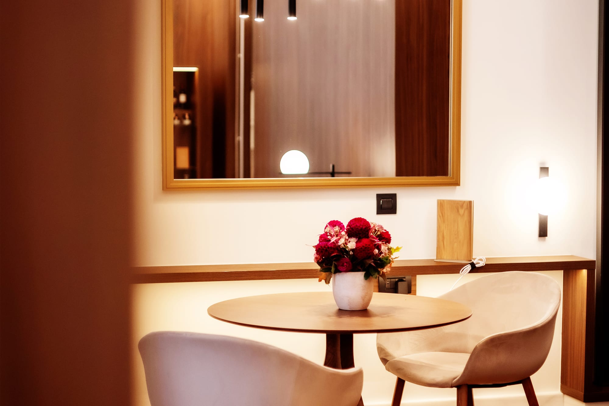 a table with chairs and a vase of flowers