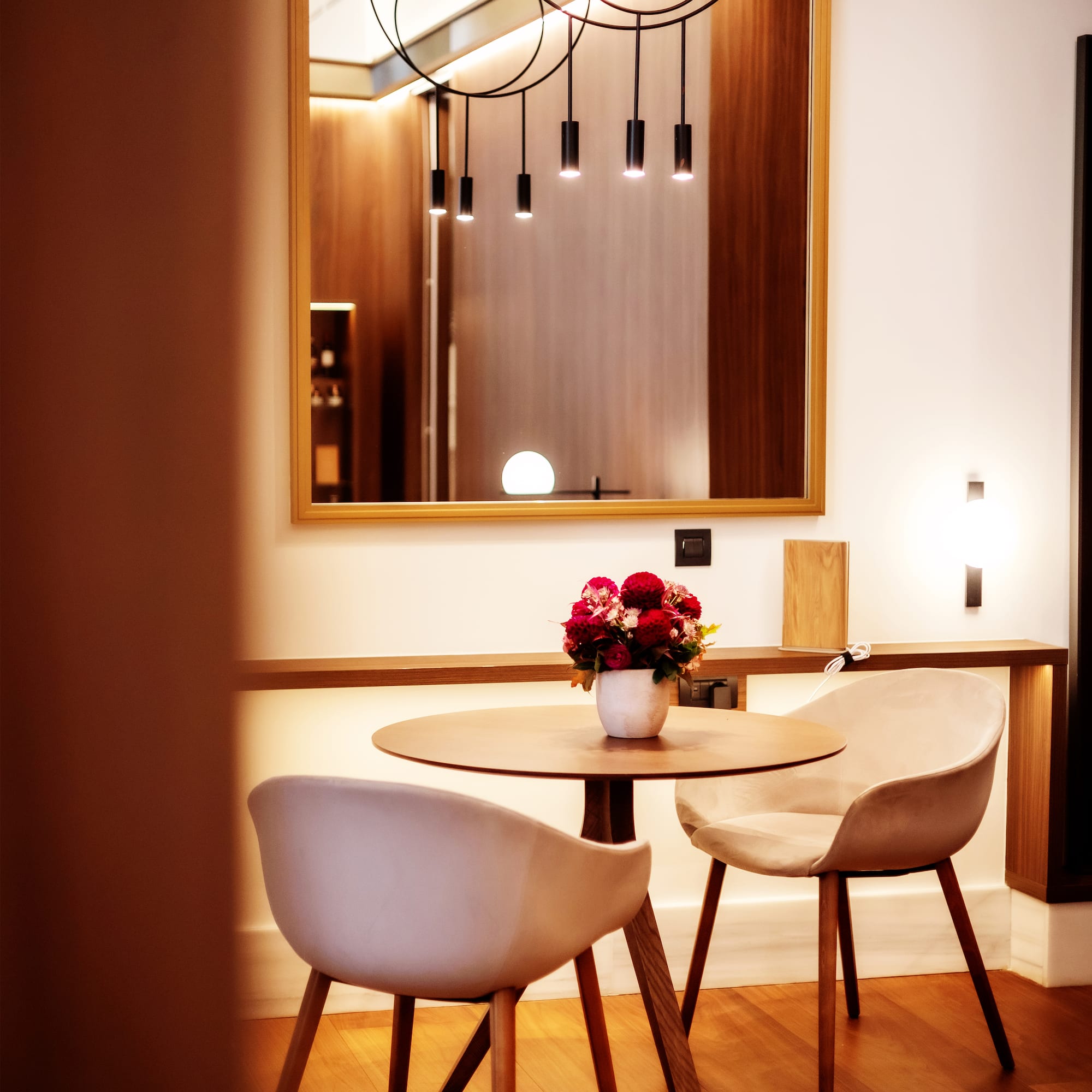 a table with chairs and a vase of flowers