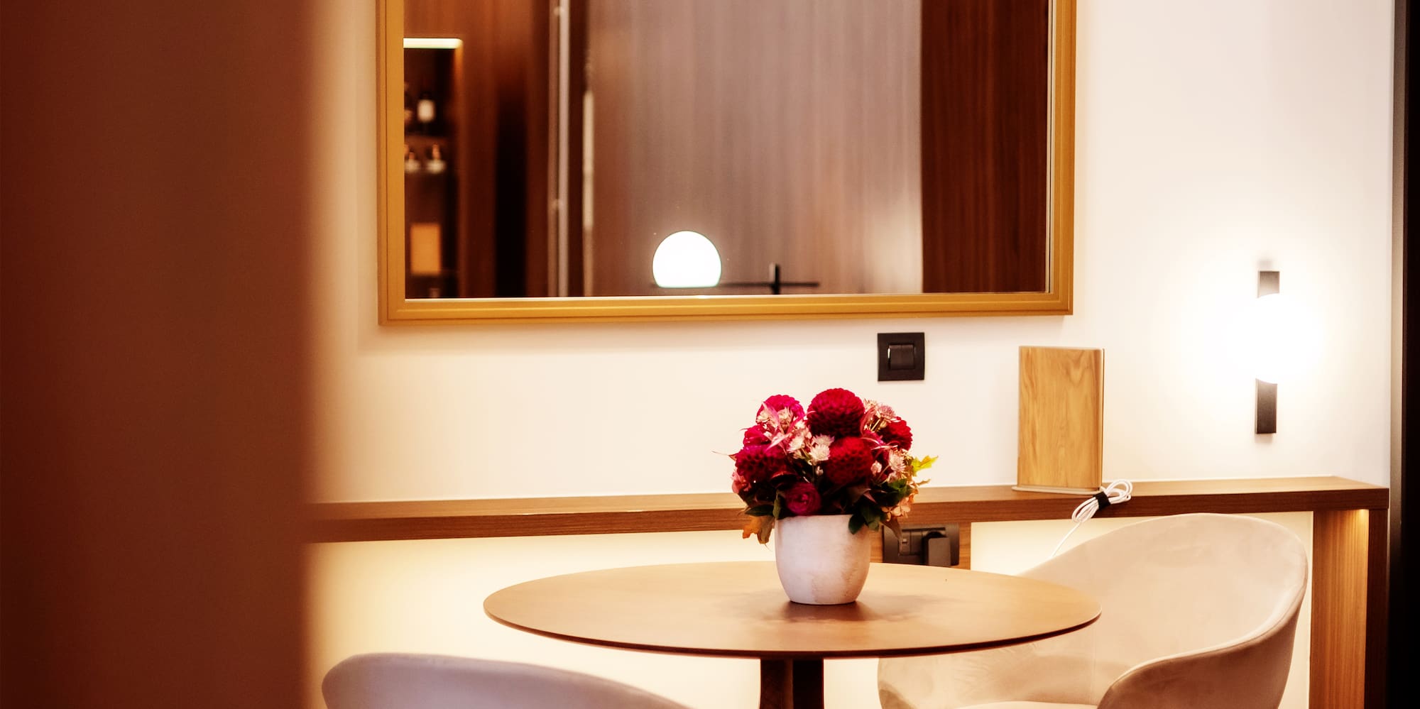 a table with chairs and a vase of flowers