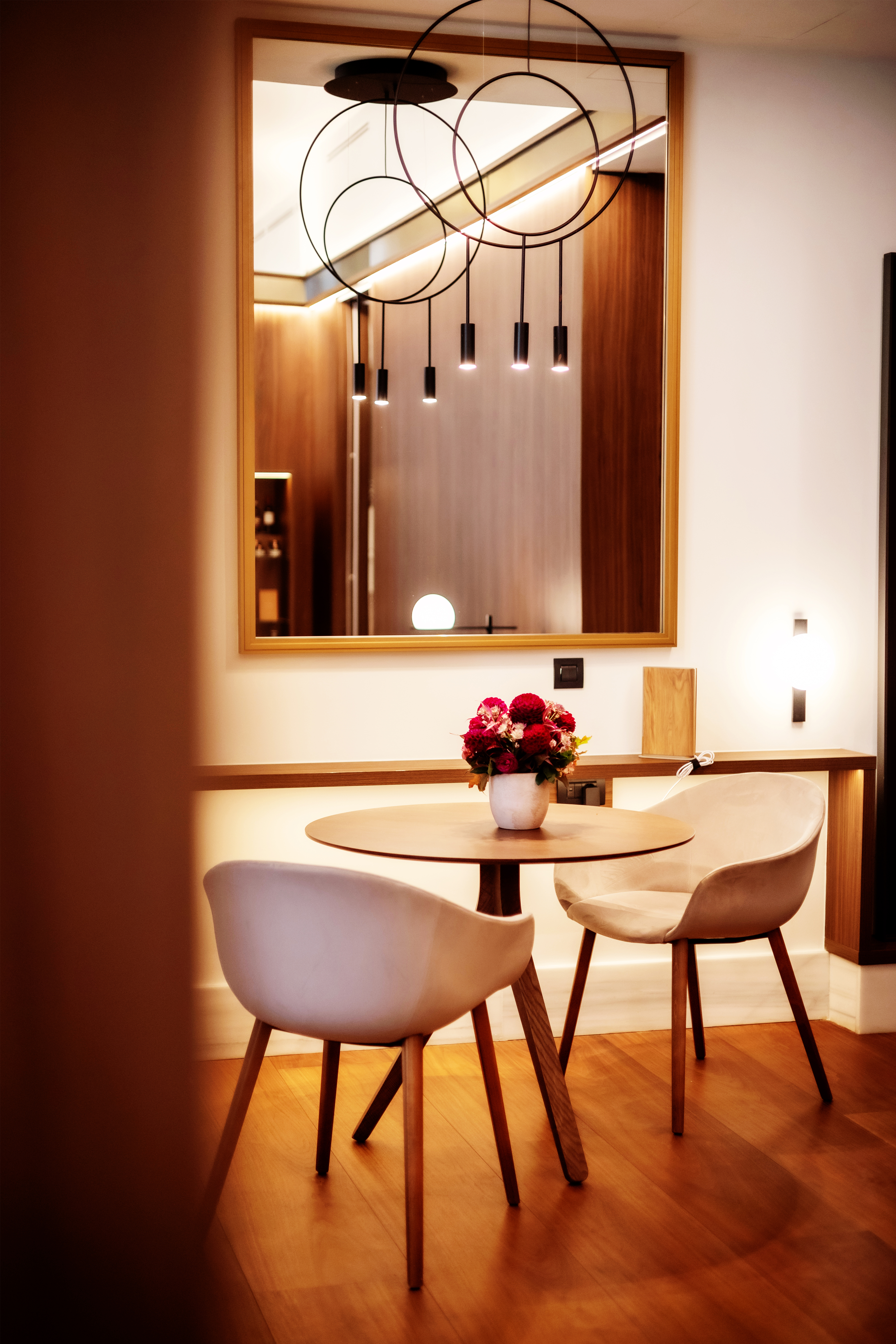 a table with chairs and a vase of flowers