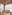 Restaurante de playa tropical con mesas de madera, decoración de mimbre y vistas al mar.