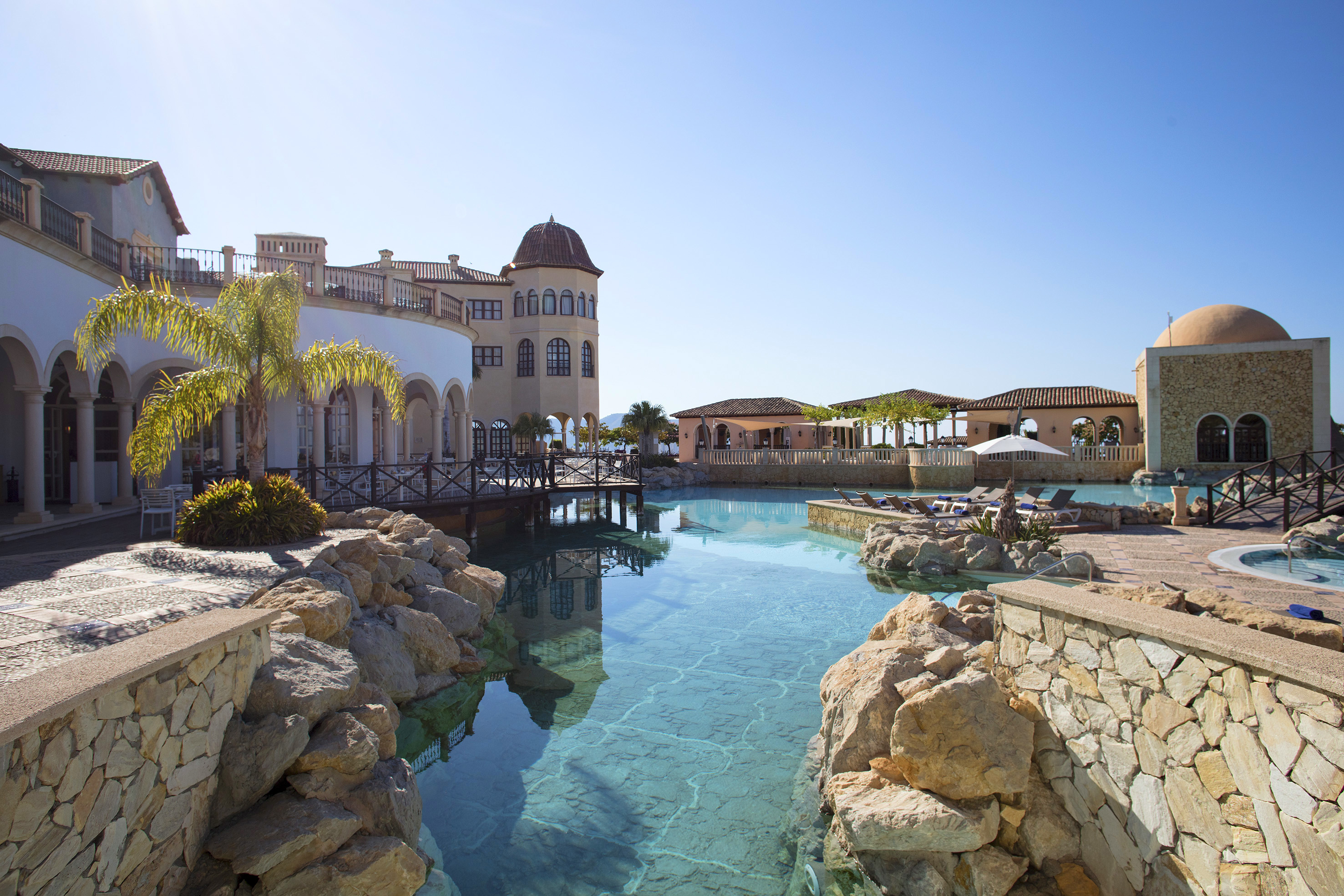 a pool with rocks and a building