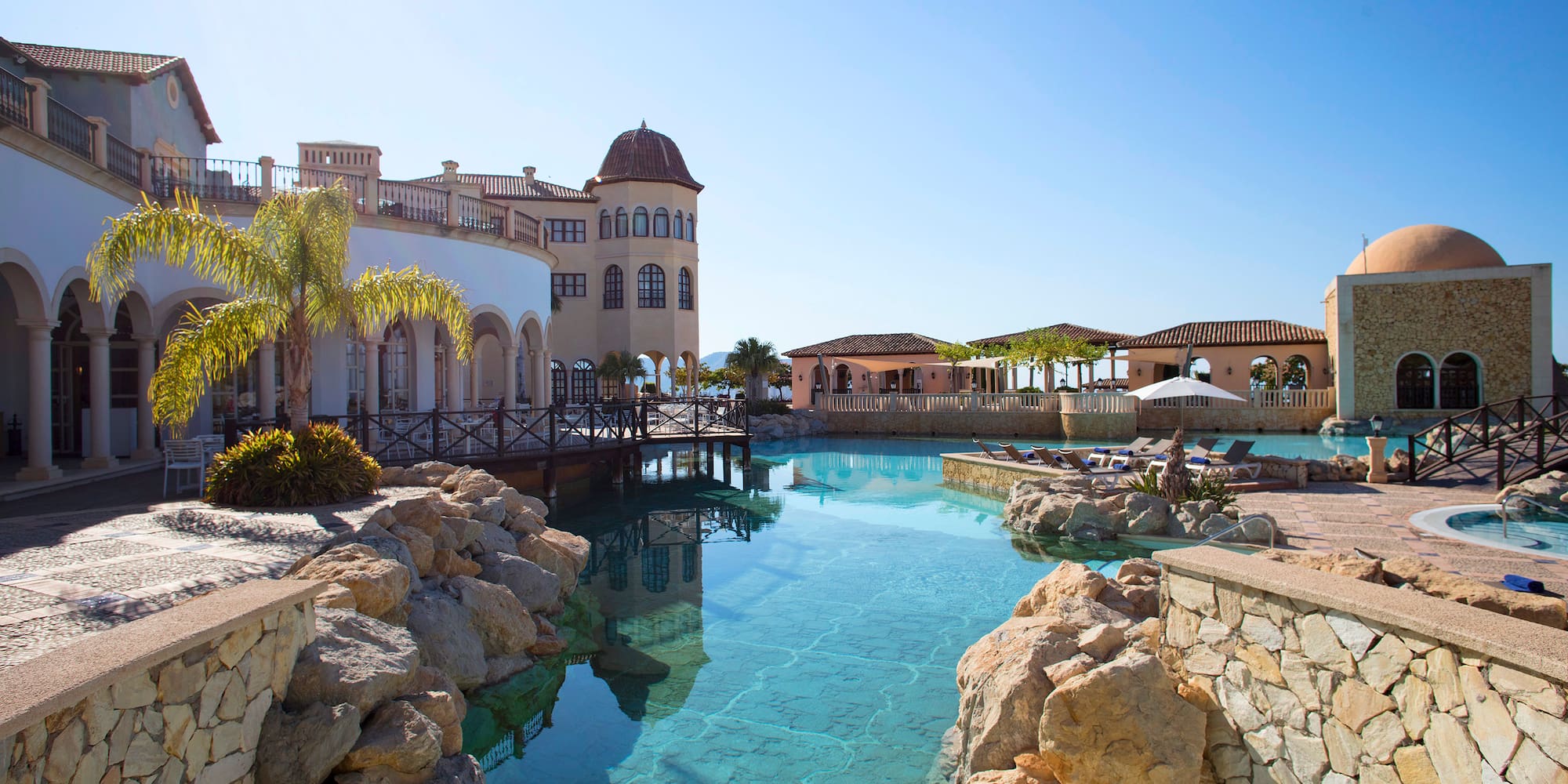 a pool with rocks and a building