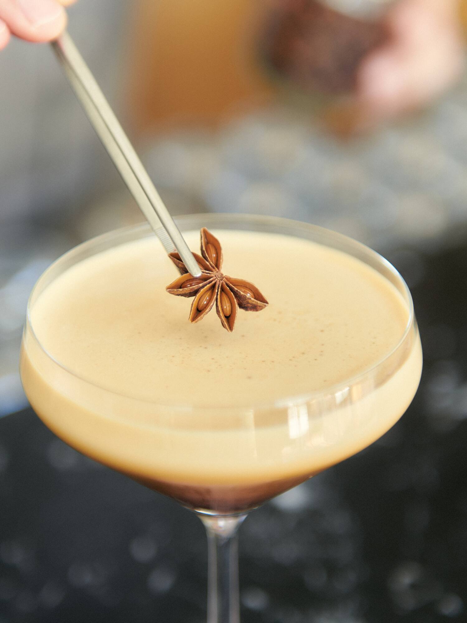 a brown liquid with anise on top