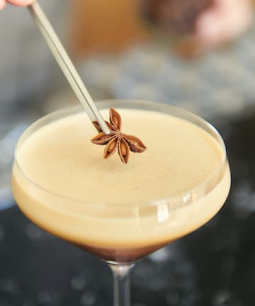 a brown liquid with anise on top