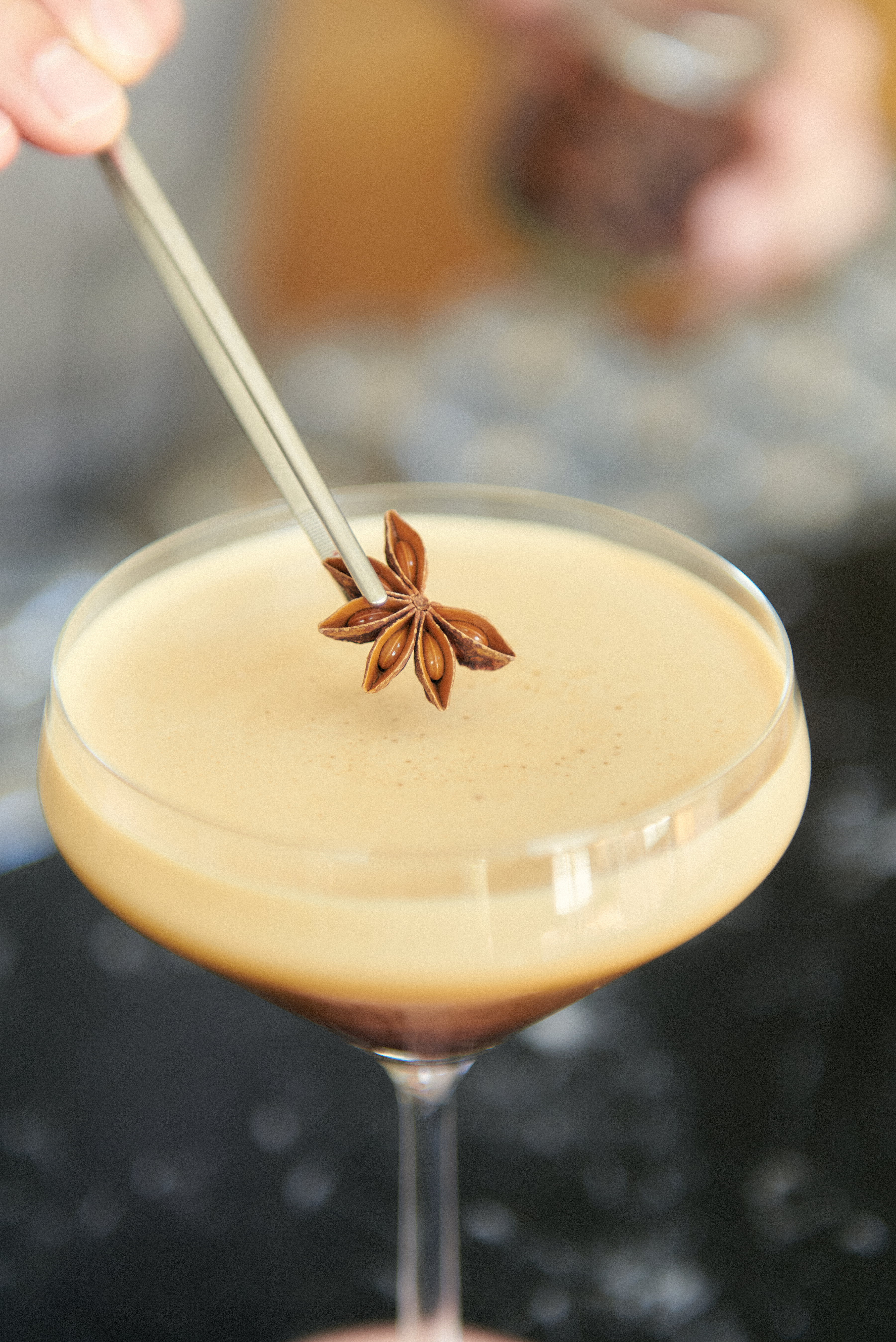 a brown liquid with anise on top