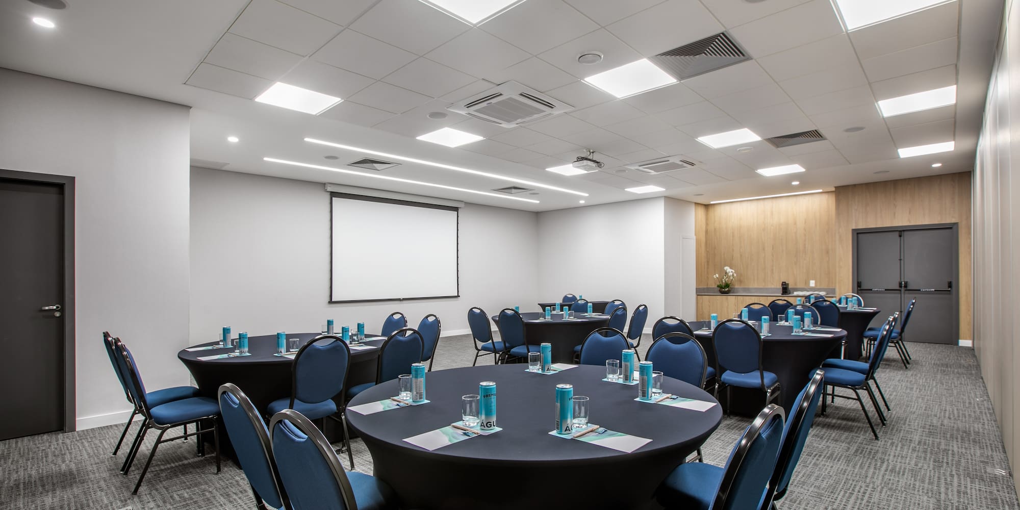 a room with round tables and blue chairs