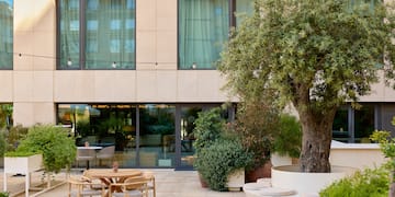 a building with a tree and chairs