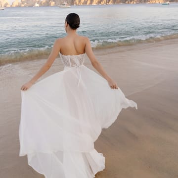 a woman in a white dress on a beach