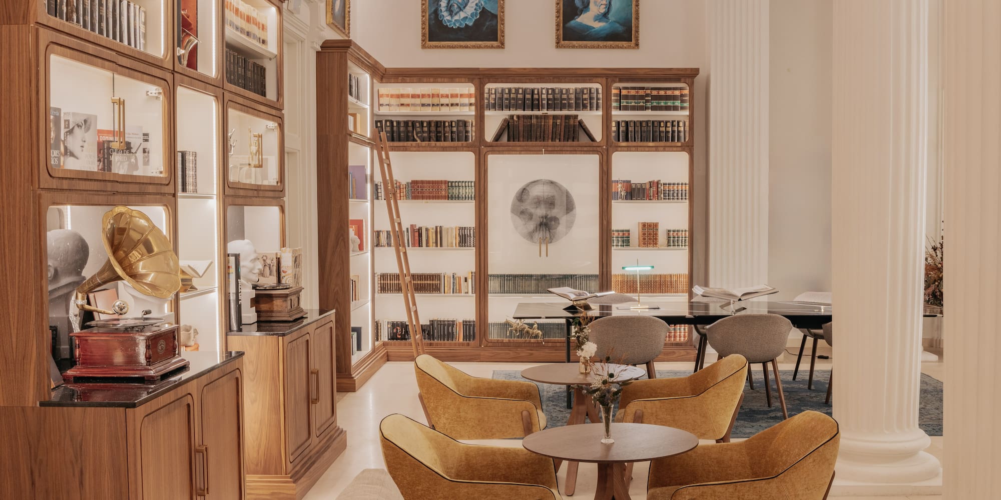 a room with bookshelves and tables and chairs