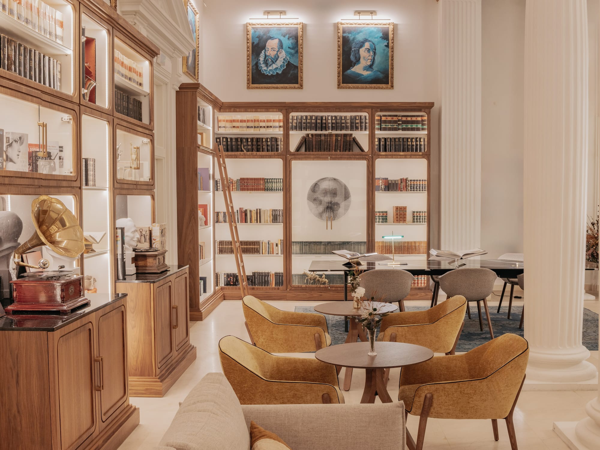 a room with bookshelves and tables and chairs