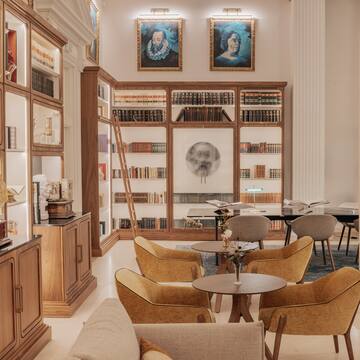 a room with bookshelves and tables and chairs