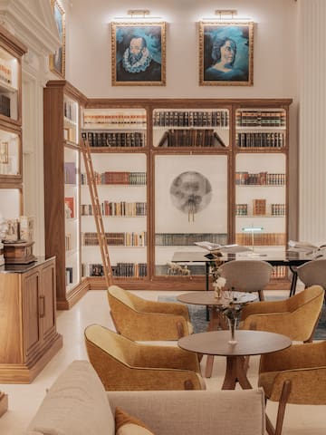 a room with bookshelves and tables and chairs