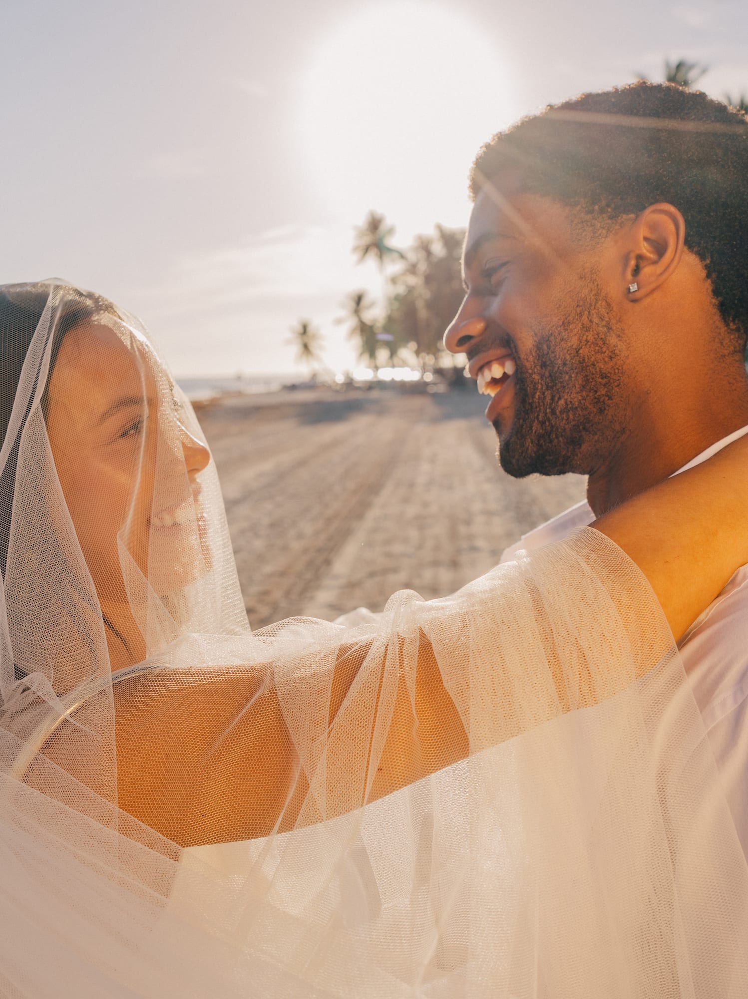 a man and woman in white dress dancing on a beach