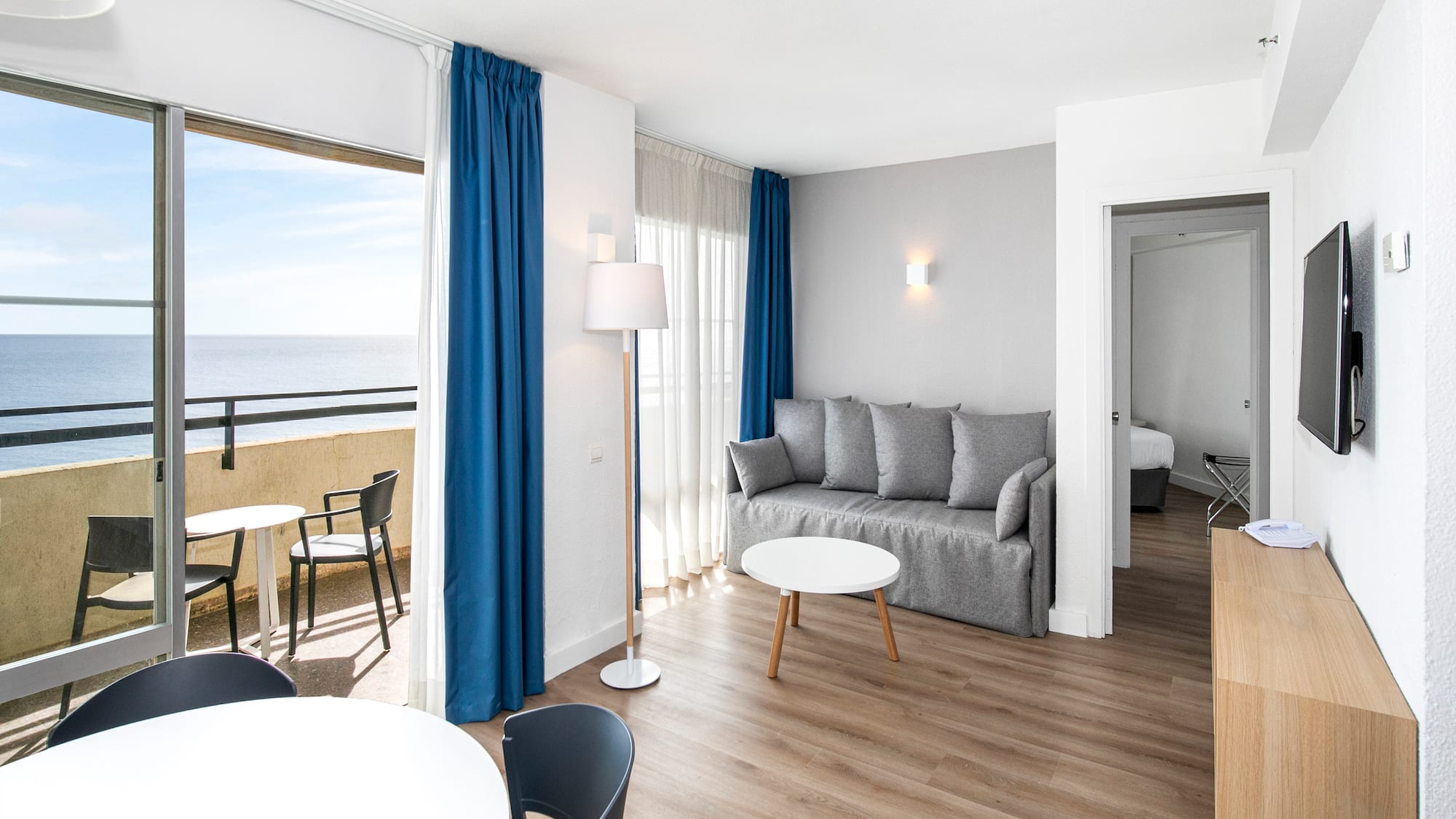 a room with a couch and table and chairs