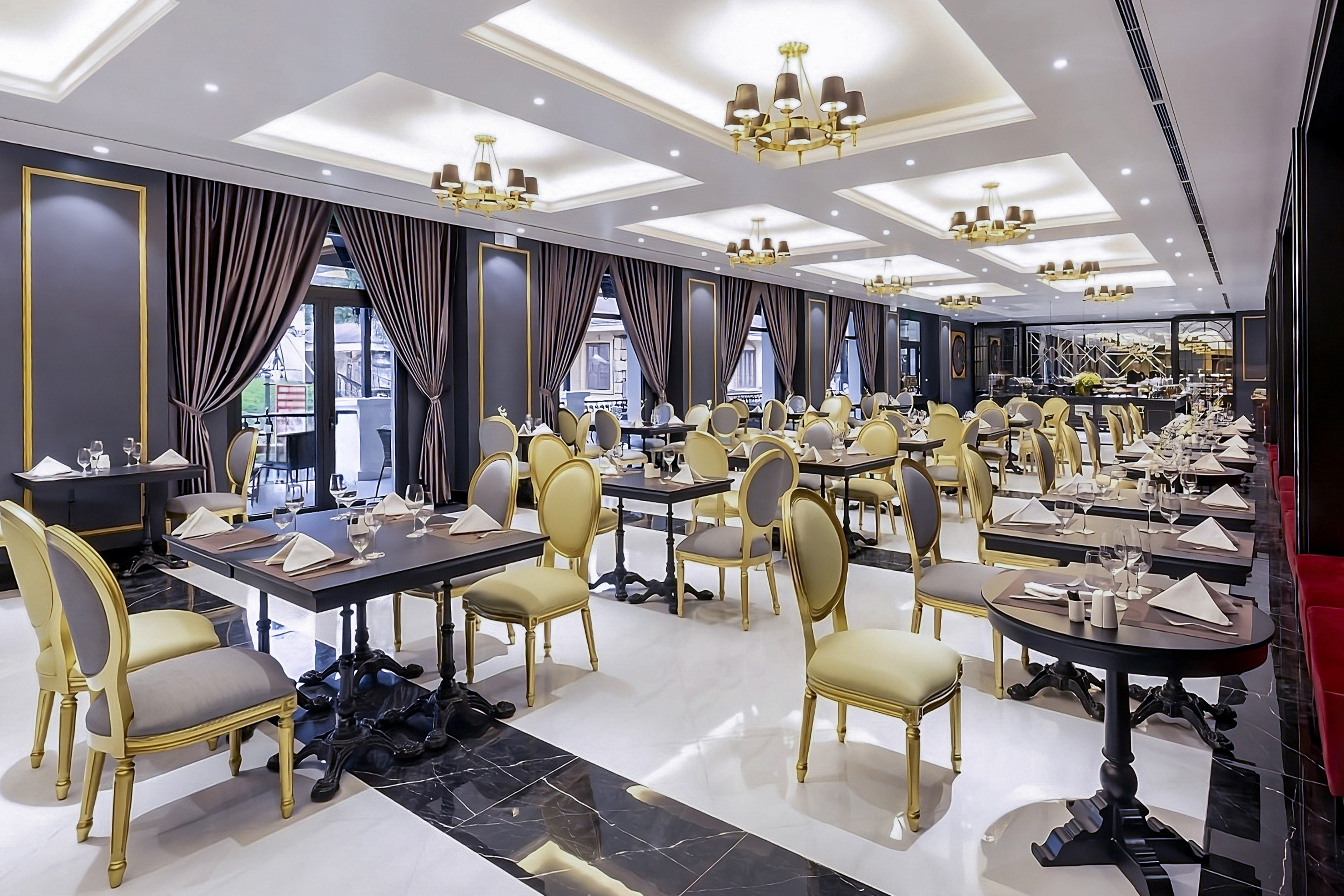 Elegant hotel restaurant dining room with set tables, gold chairs, and chandeliers. - Restaurante BB, Cocina fusión asiática - Hotel Sapa Square Affiliated by Meliá, Sapa