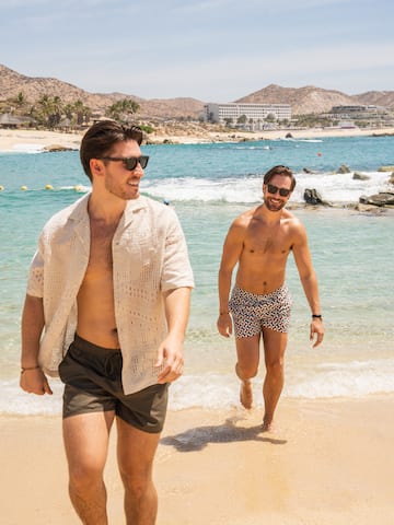 two men walking on a beach