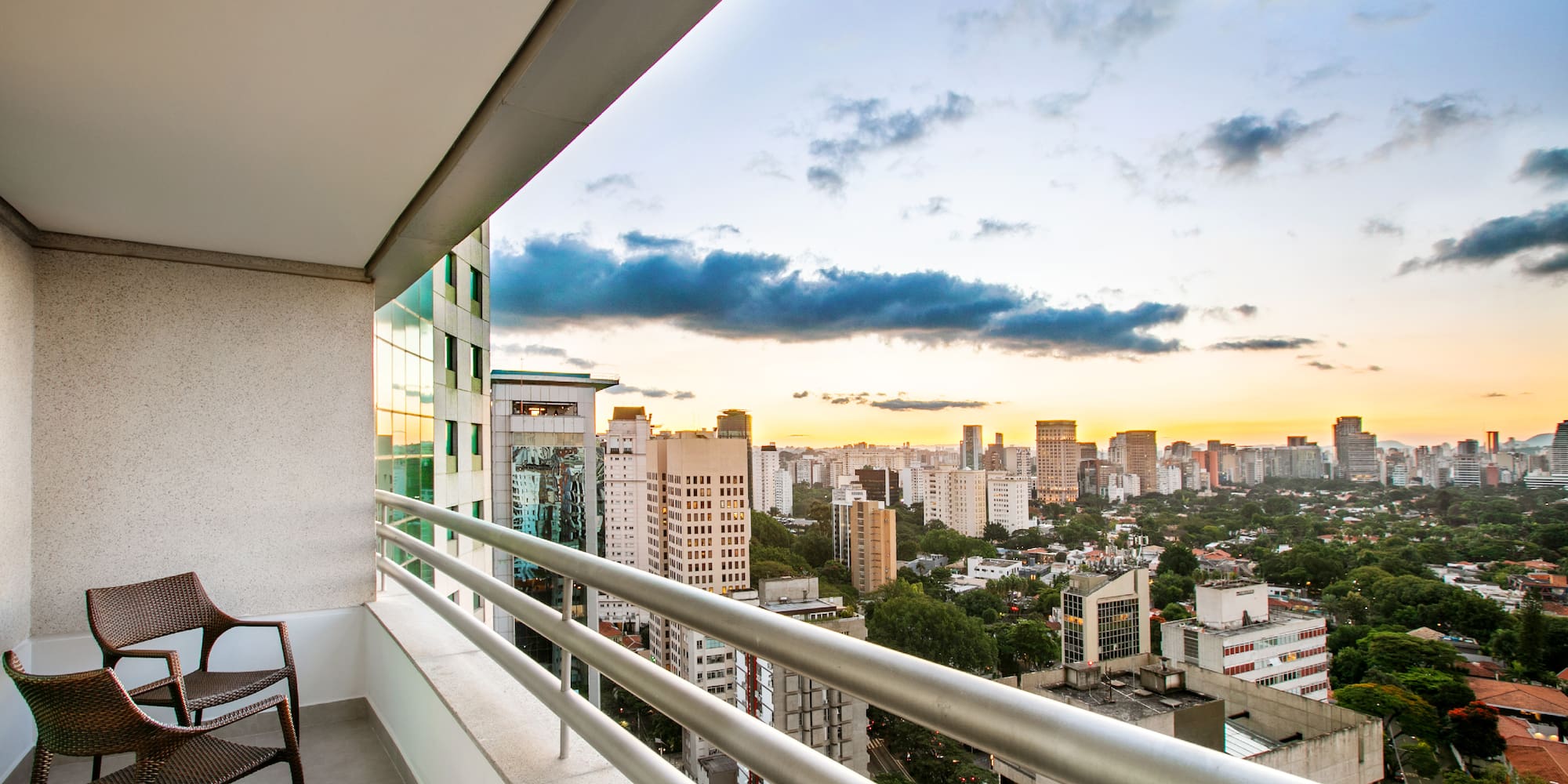 a balcony with a chair and a city view