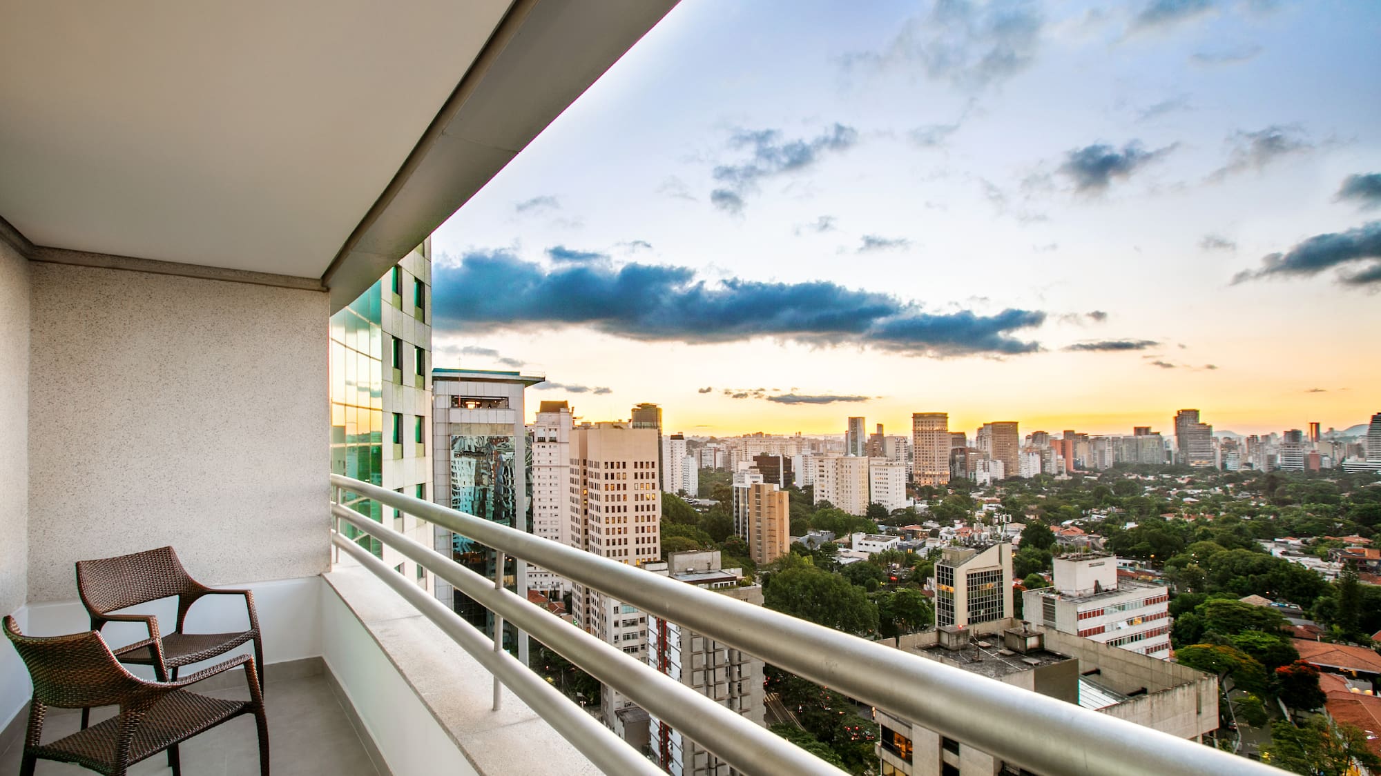 a balcony with a chair and a city view