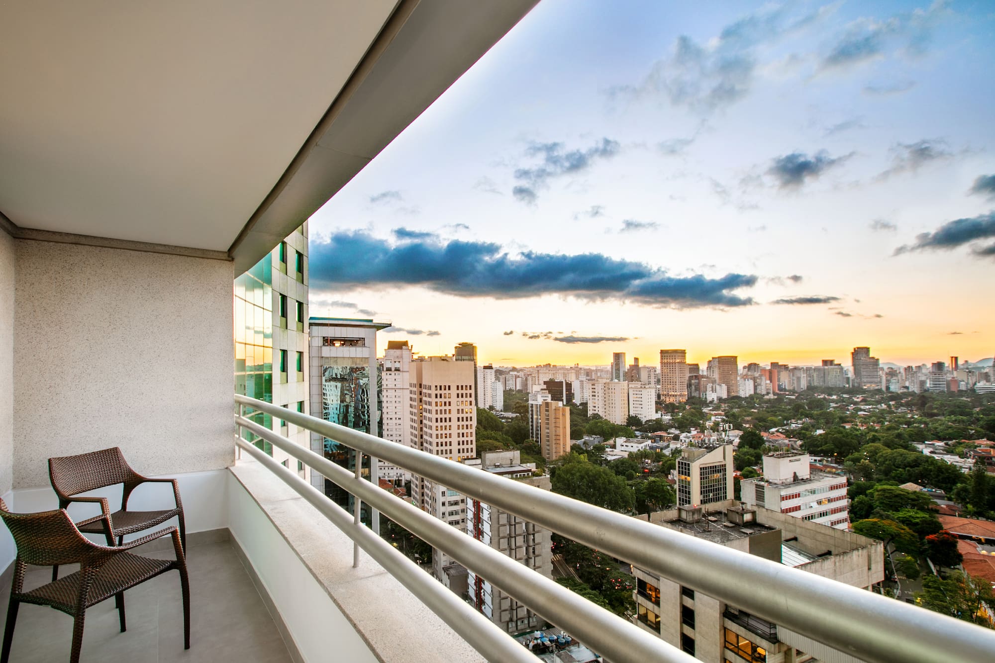 a balcony with a chair and a city view