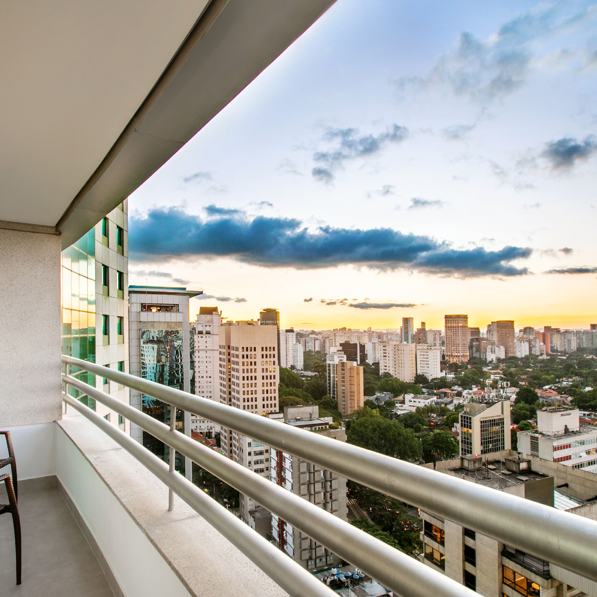 a balcony with a chair and a city view
