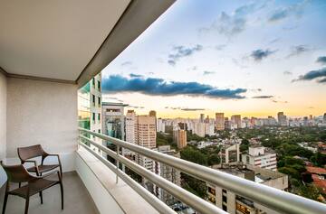 a balcony with a chair and a city view