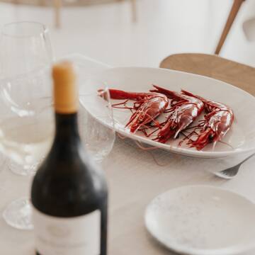 a plate of shrimp and wine on a table