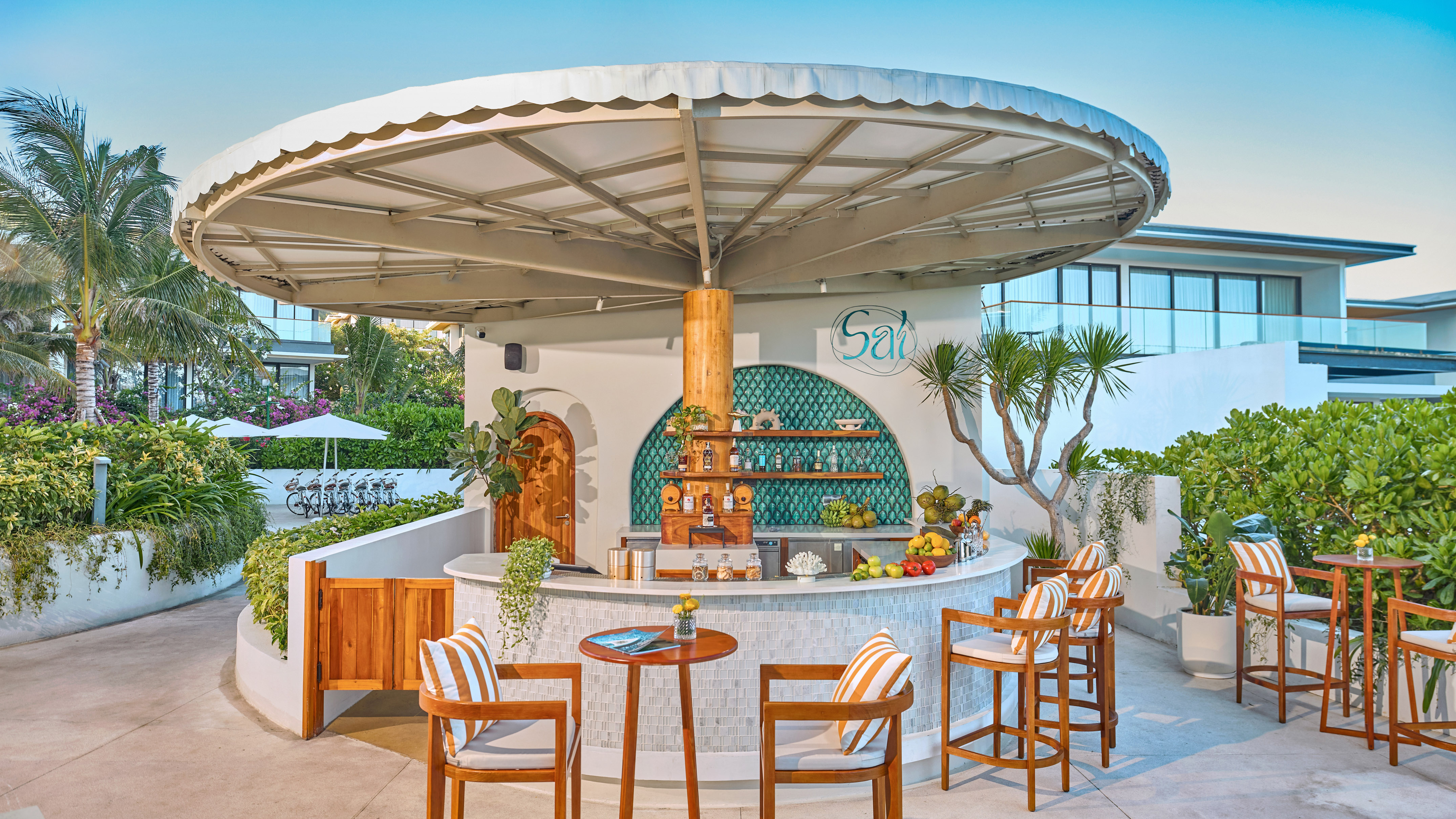 "Salt" outdoor bar area with tropical plants, seating, and resort setting.