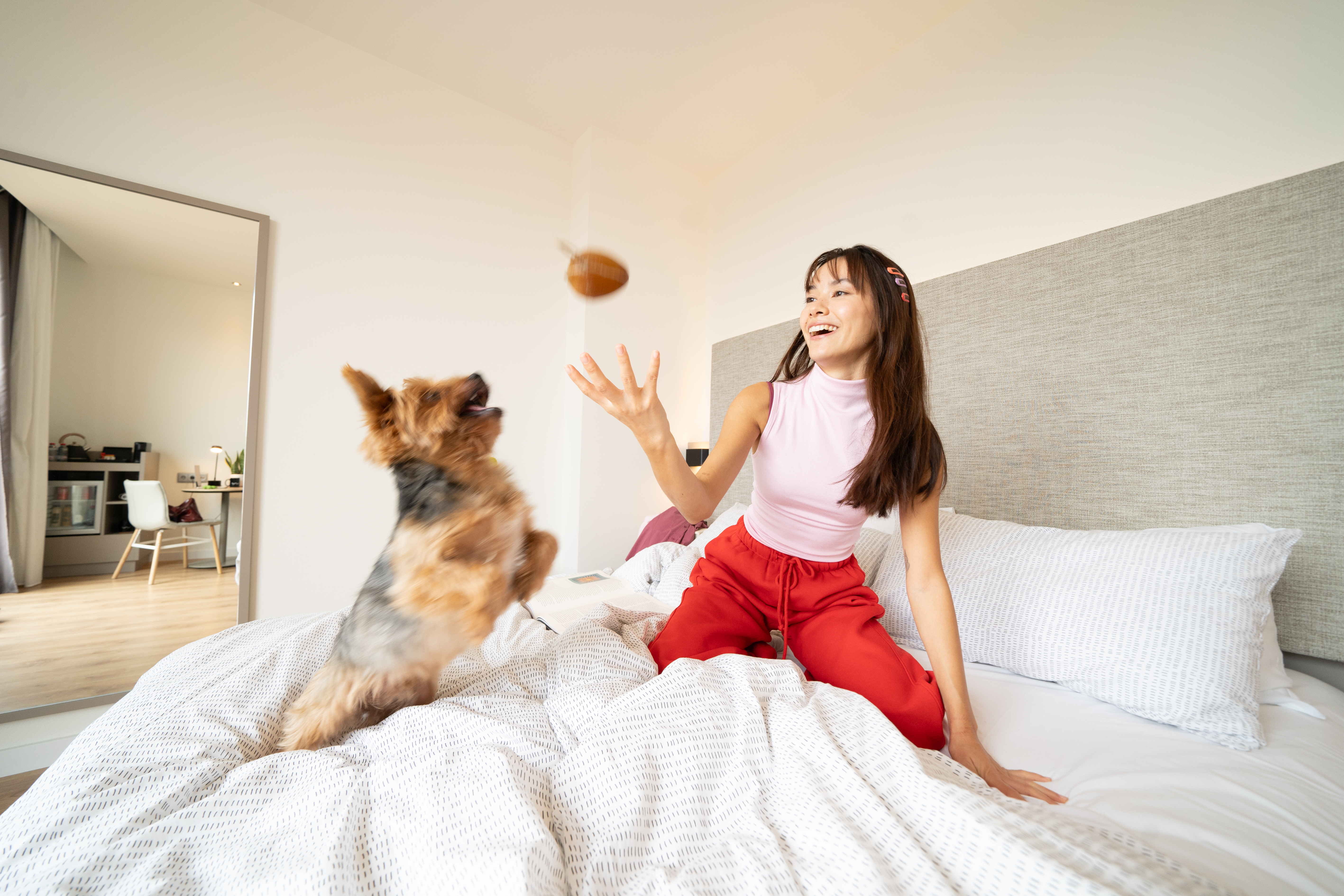 a woman on a bed with a dog