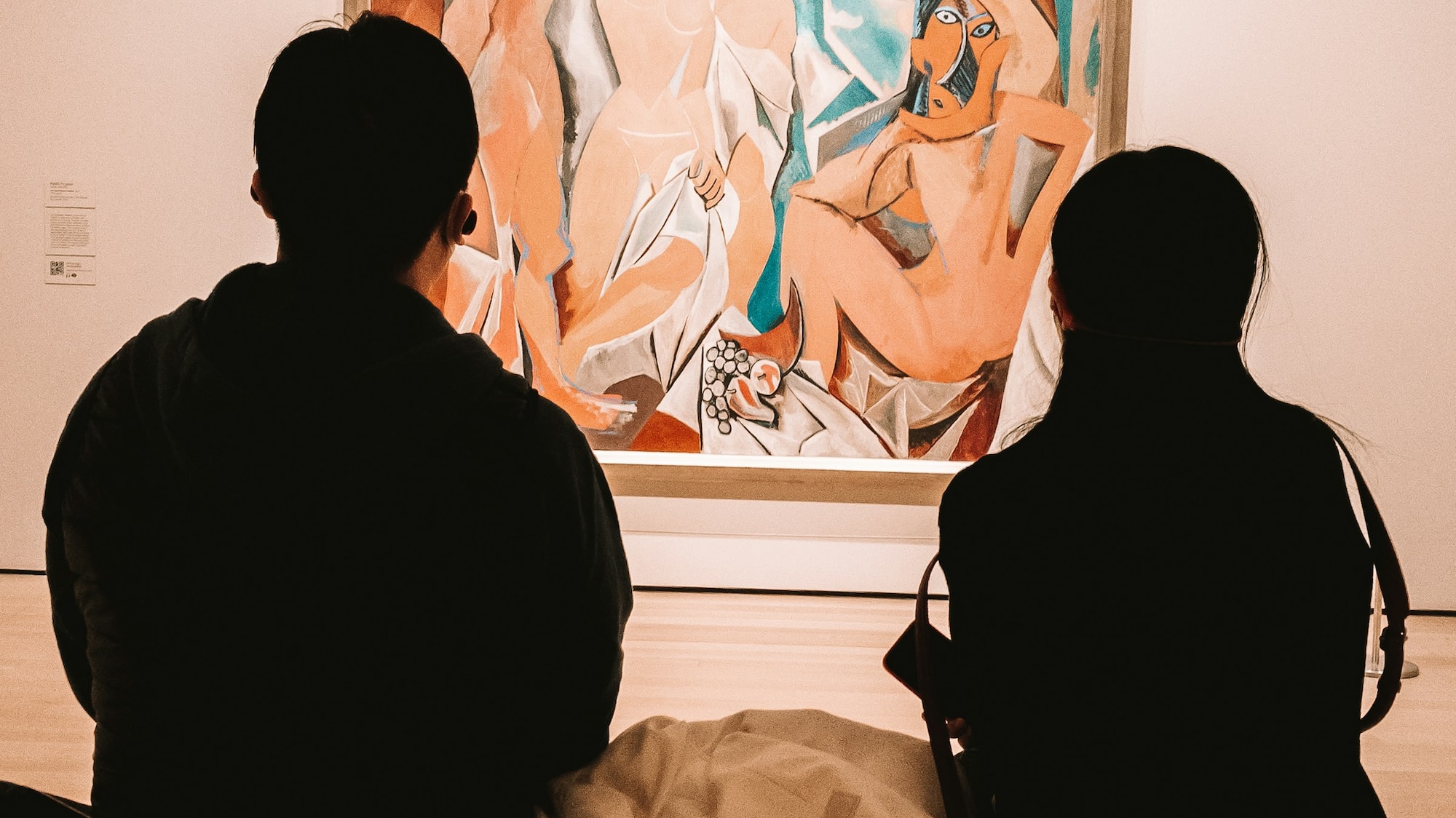 a group of people looking at a painting