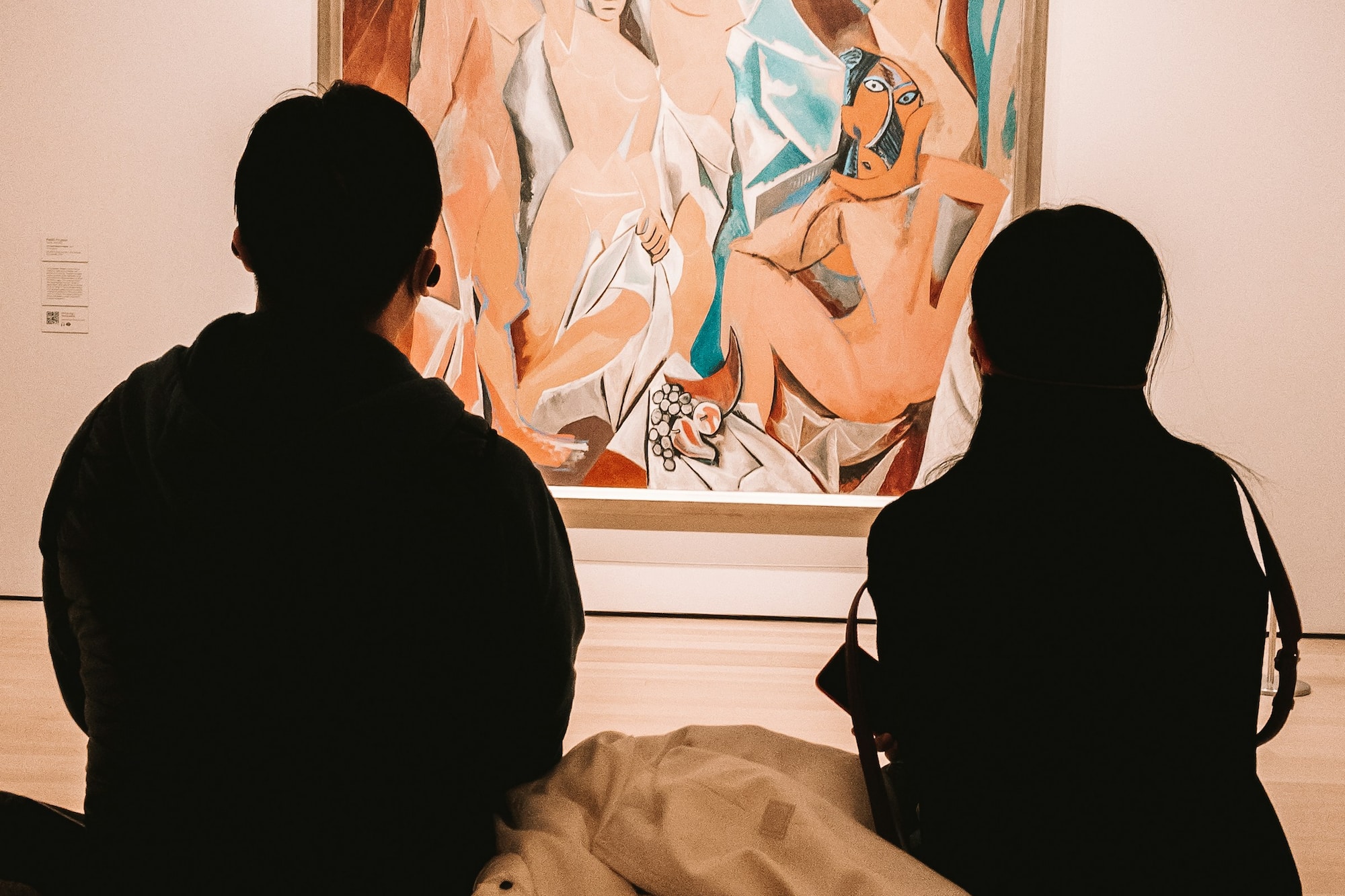 a group of people looking at a painting