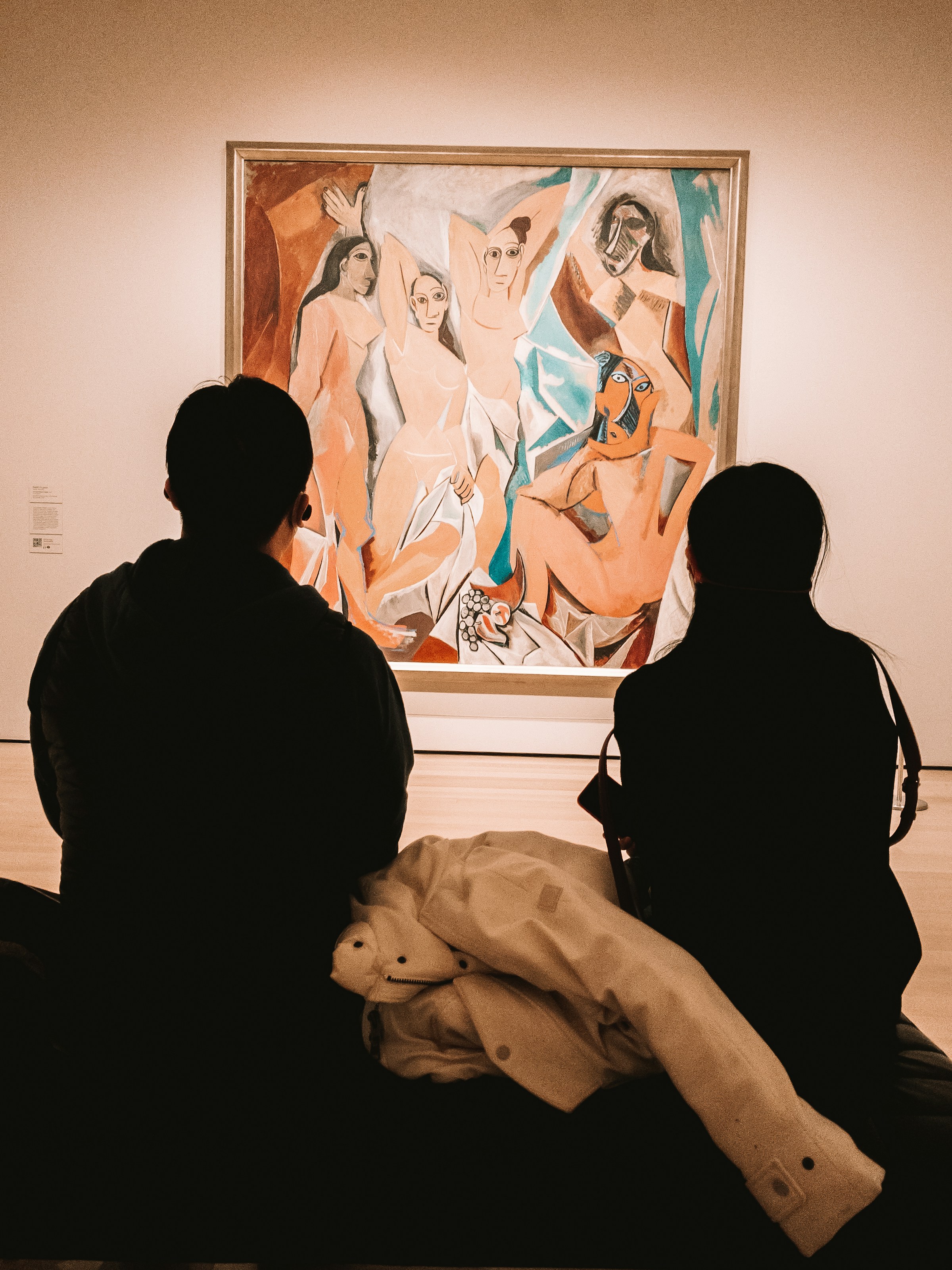 a group of people looking at a painting