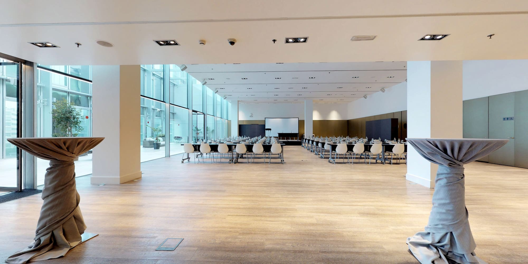 Modern conference room setup with projection screen and large glass walls.
