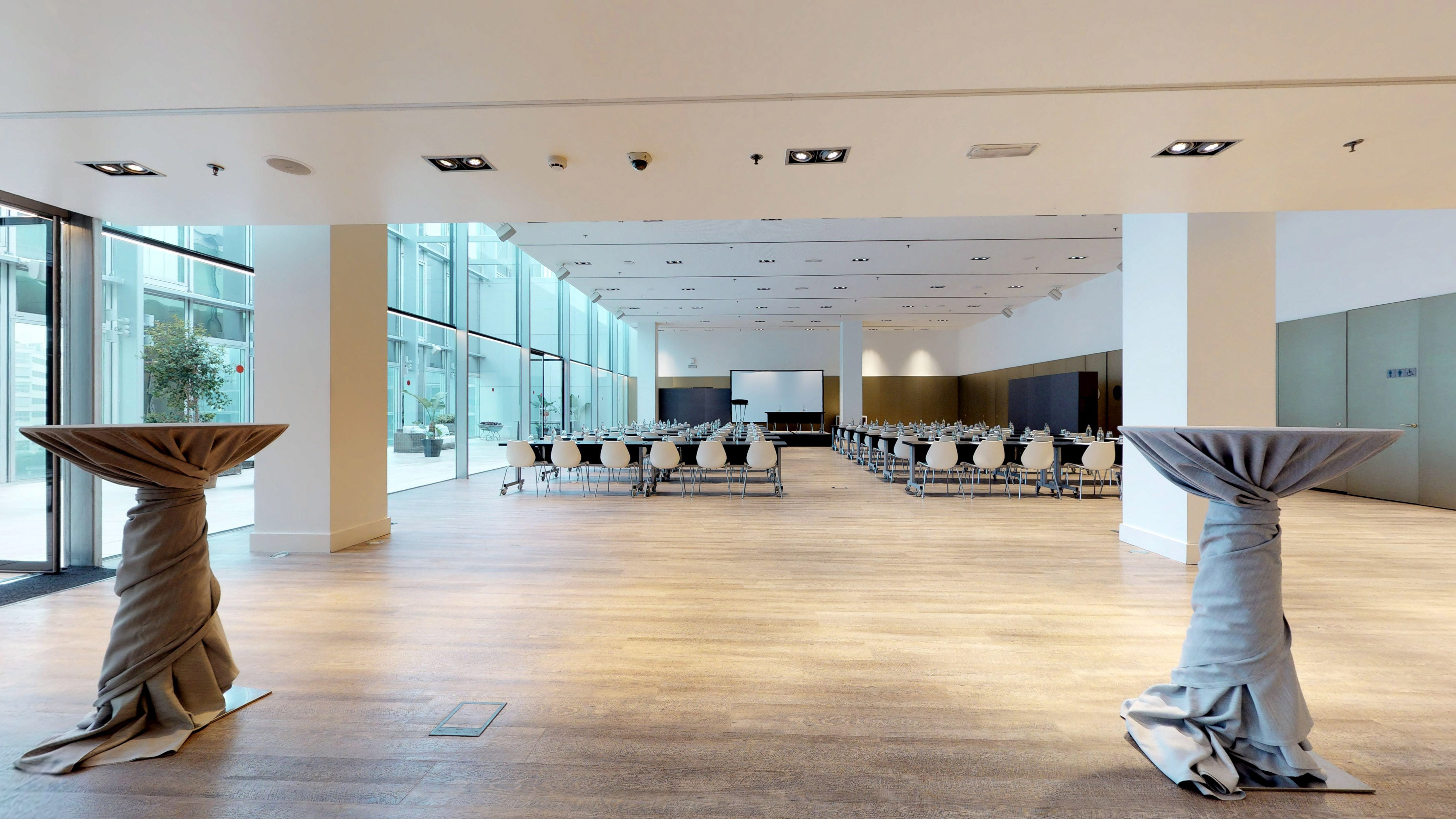 Modern conference room setup with projection screen and large glass walls.