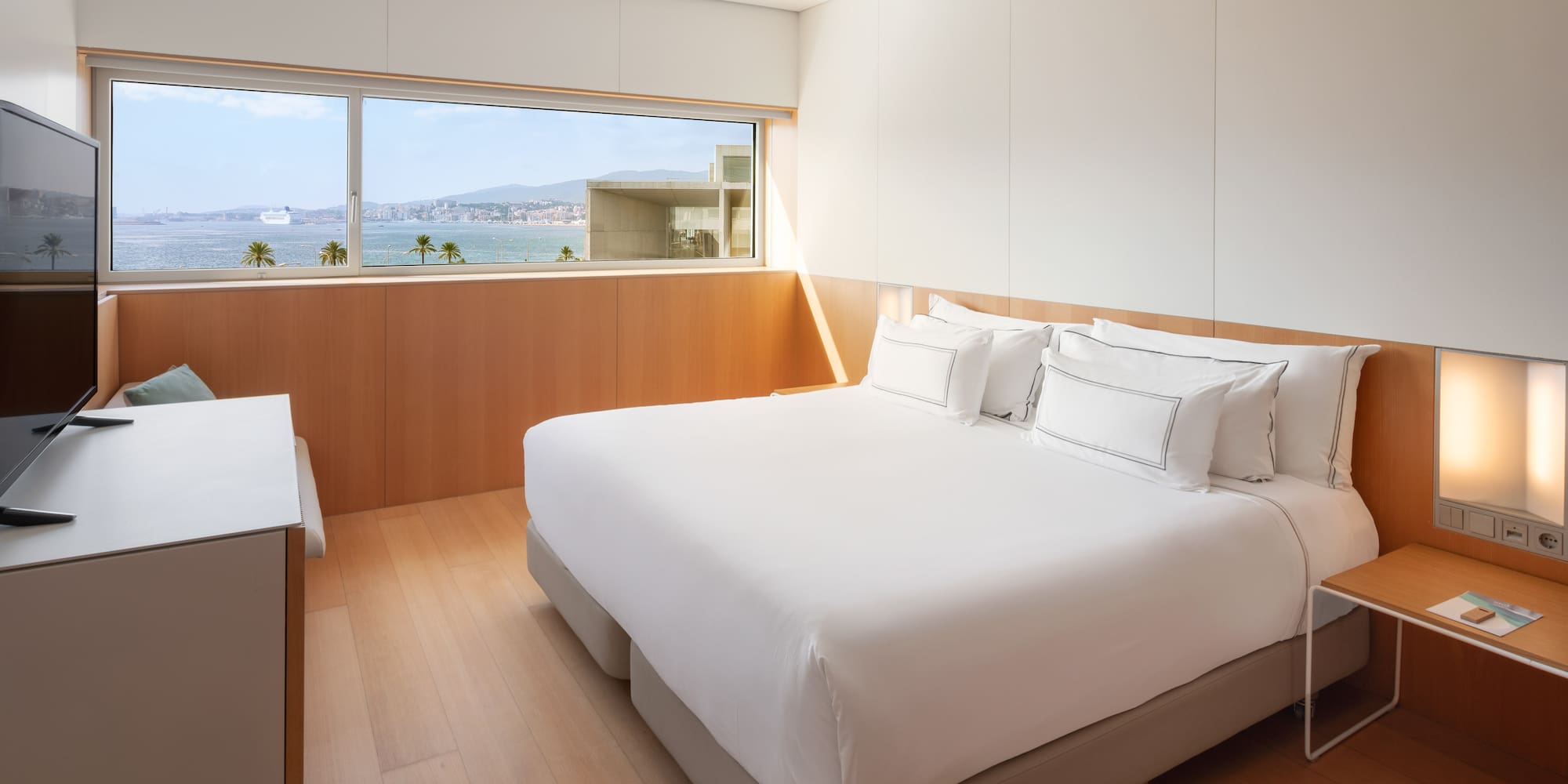 a bedroom with a large window overlooking the water