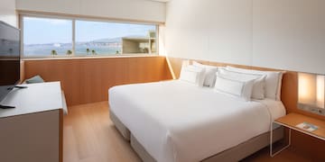 a bedroom with a large window overlooking the water