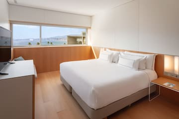 a bedroom with a large window overlooking the water