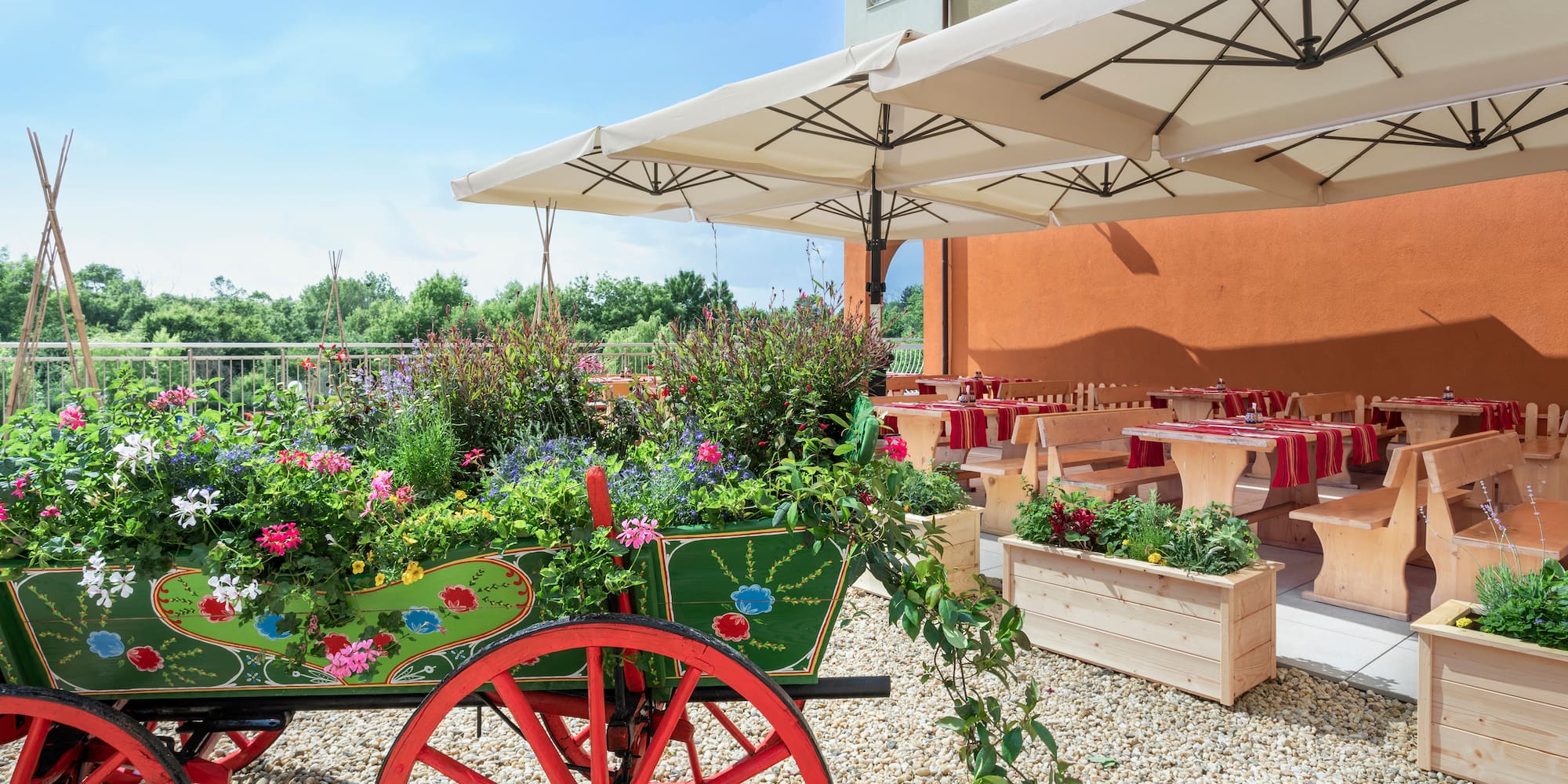 a wagon with flowers and tables under a white umbrella