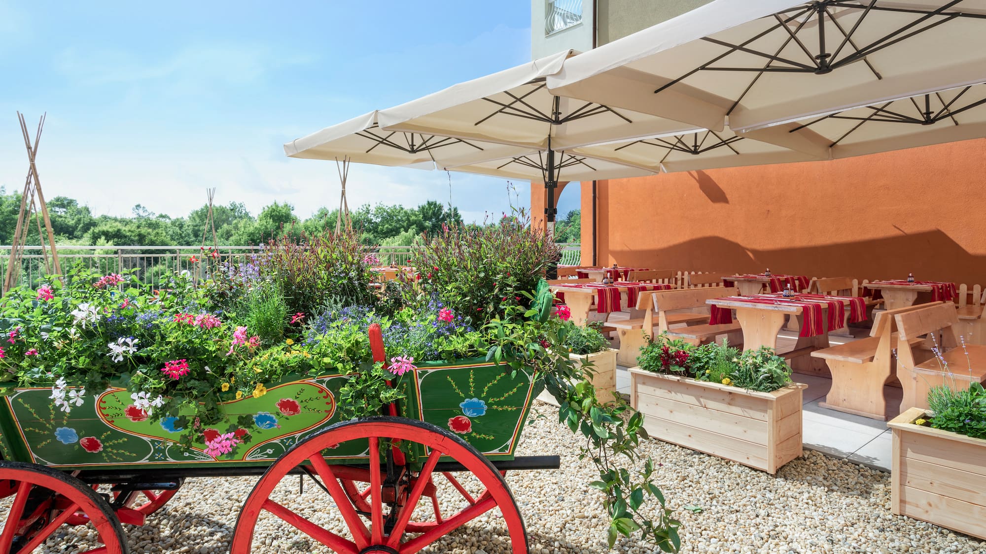 a wagon with flowers and tables under a white umbrella