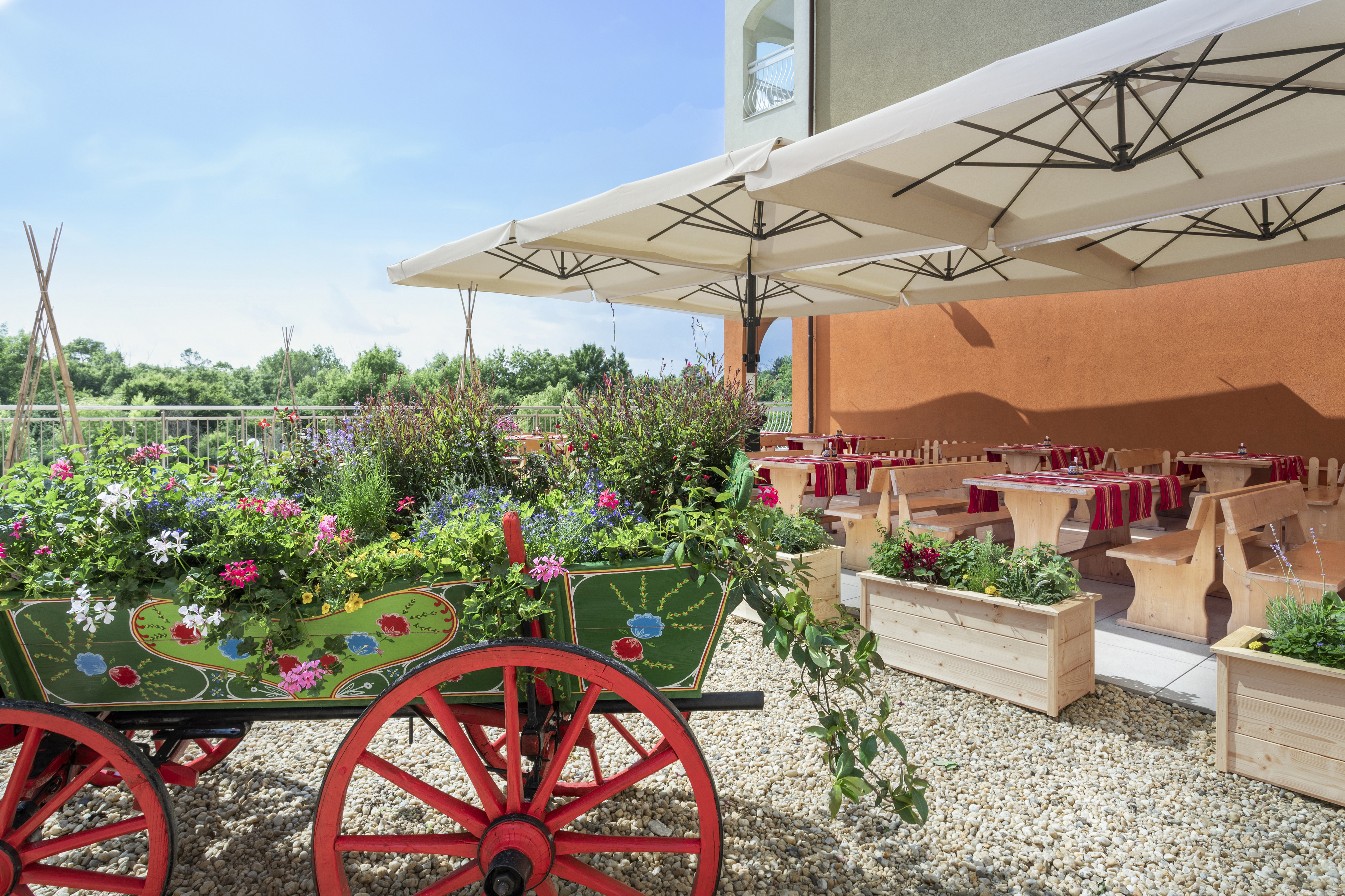 a wagon with flowers and tables under a white umbrella