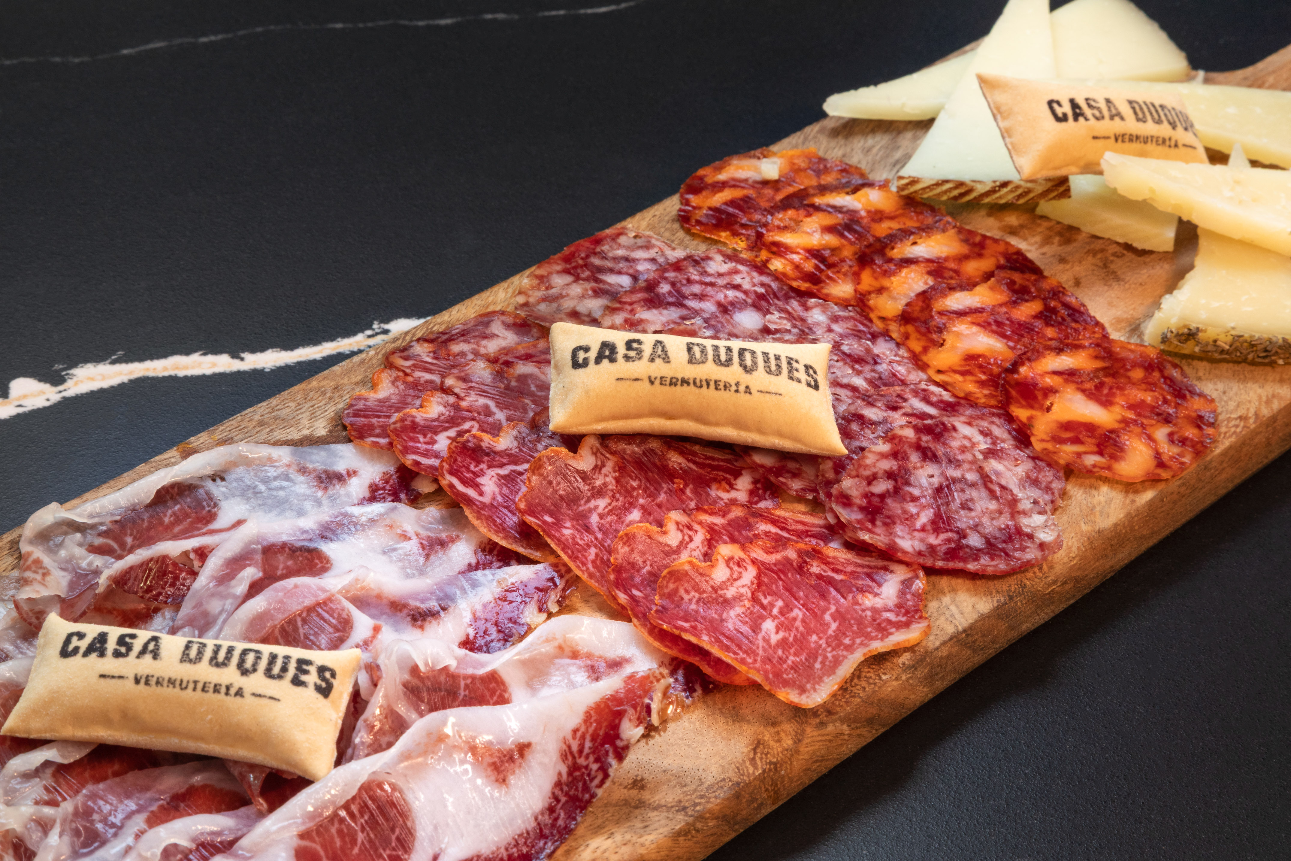Casa Duques charcuterie board: cured meats (jamón, chorizo) and cheeses.