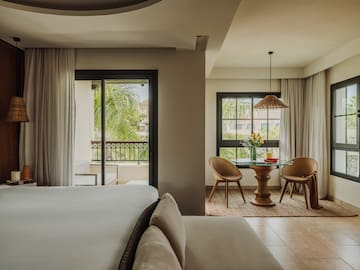 a room with a bed and chairs and a table