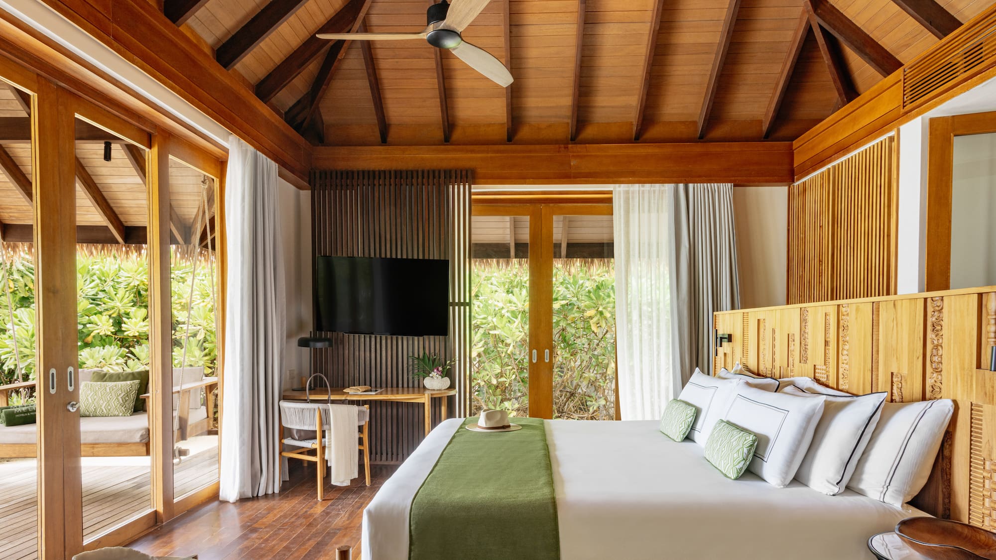a bathroom with a tub and chairs under a roof