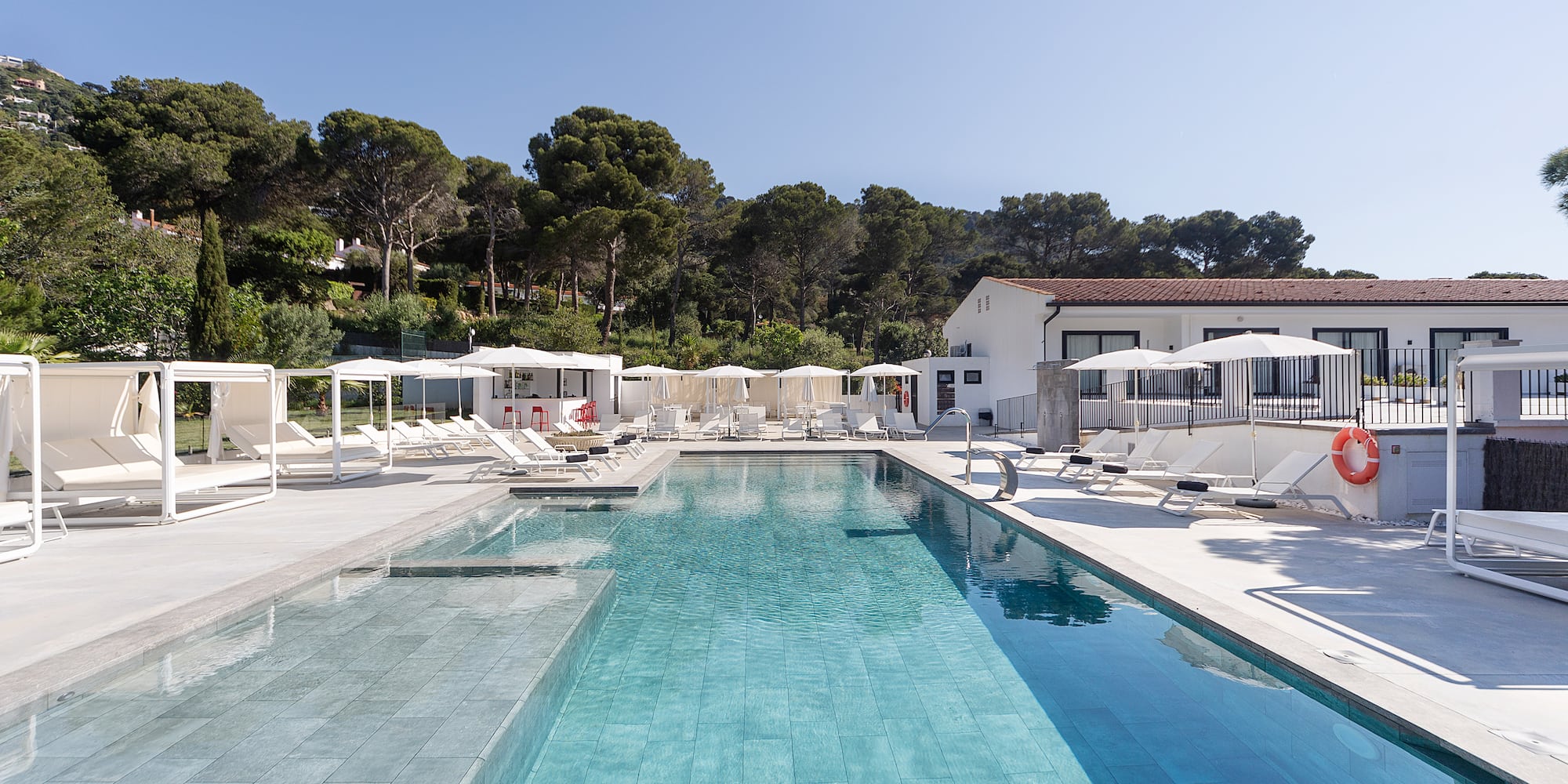 a swimming pool with chairs and umbrellas