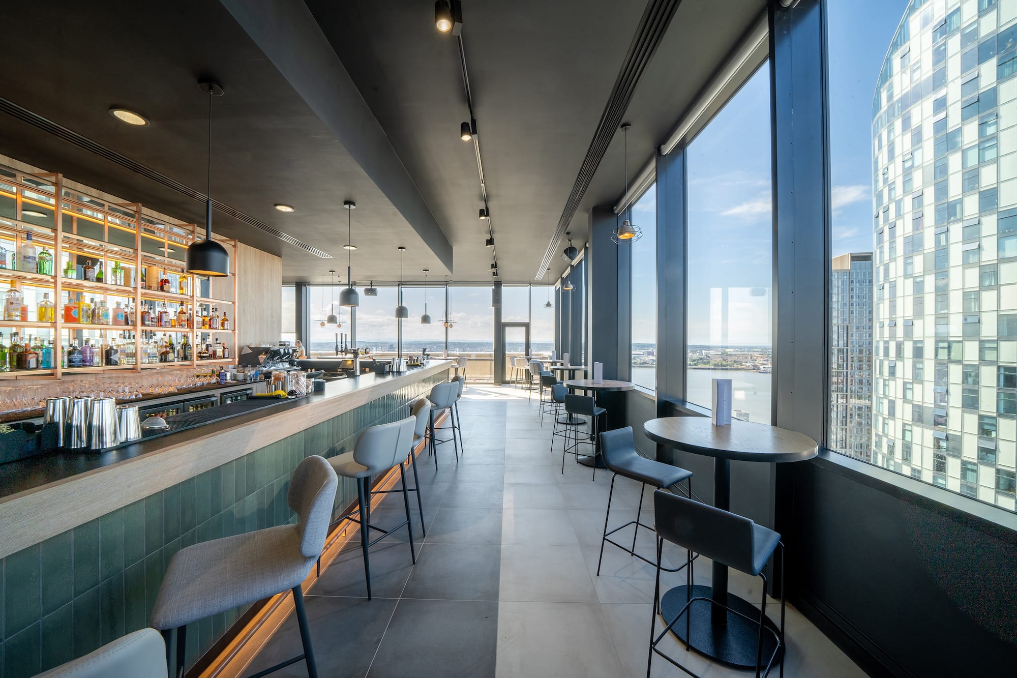 Modern bar with panoramic city skyline and waterfront views.