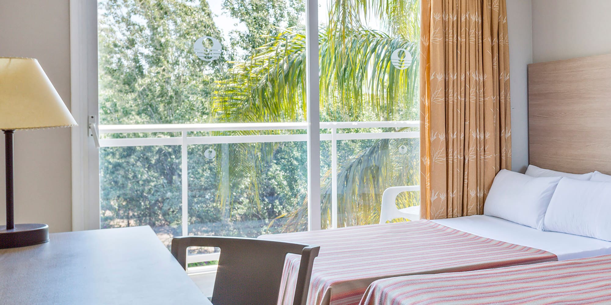 a room with two beds and a table and a lamp