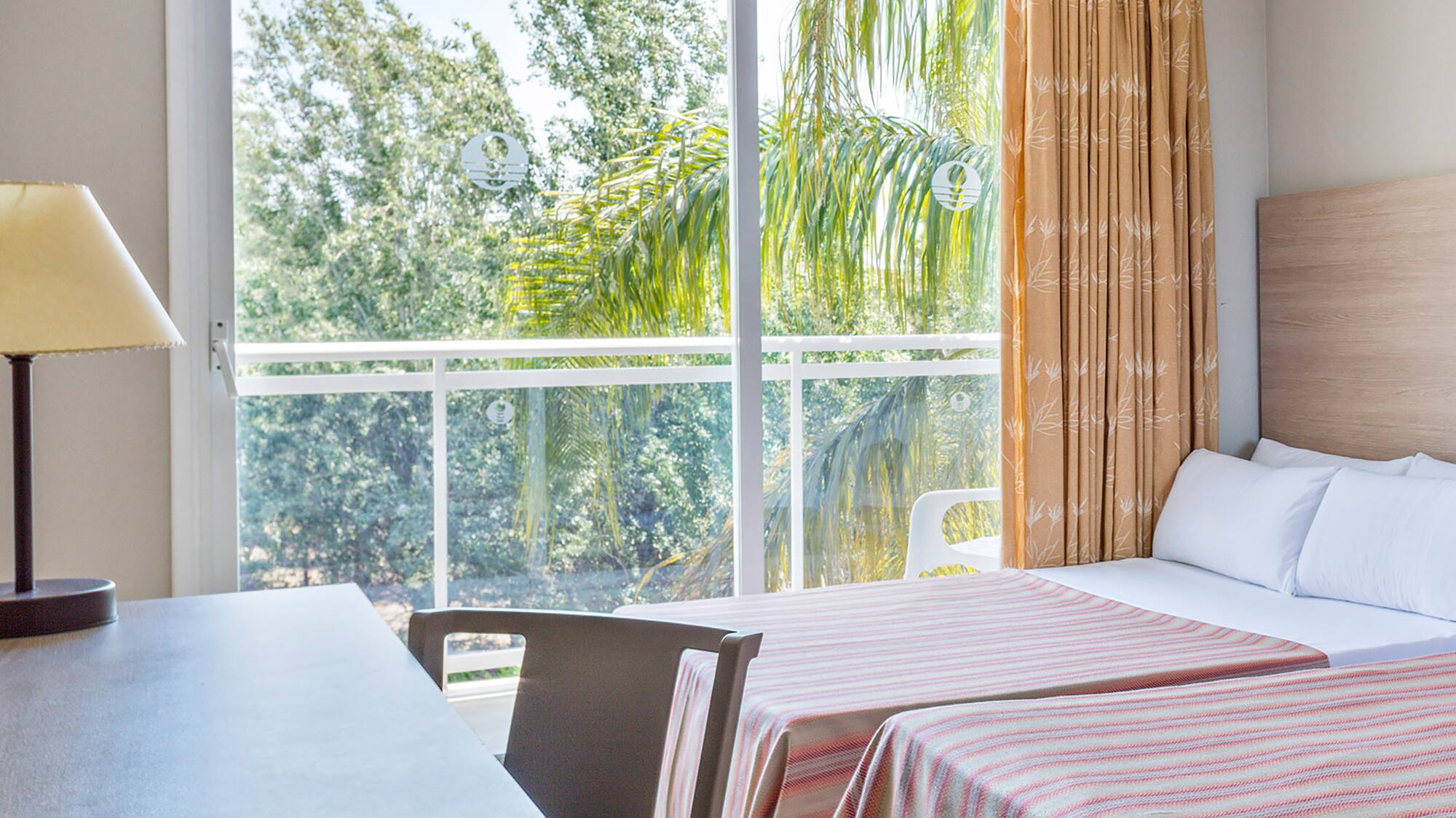 a room with two beds and a table and a lamp