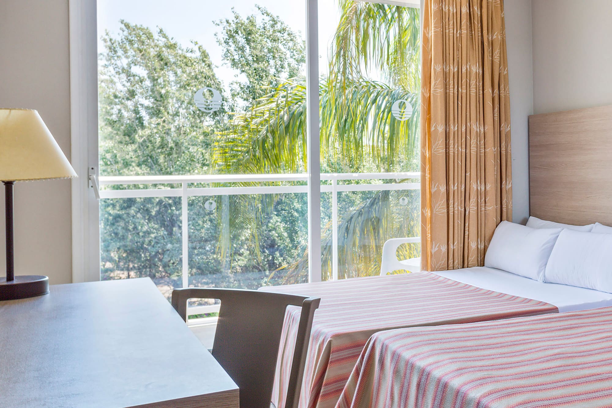 a room with two beds and a table and a lamp