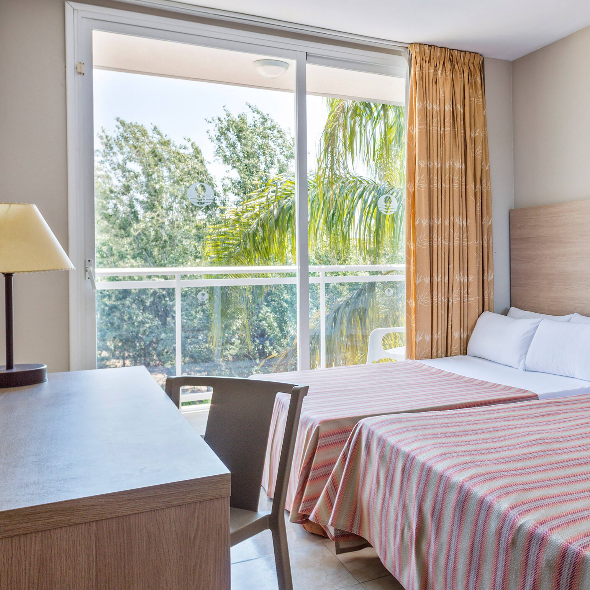 a room with two beds and a table and a lamp